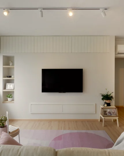 Minimal TV feature wall with vertical panels and mounted screen.