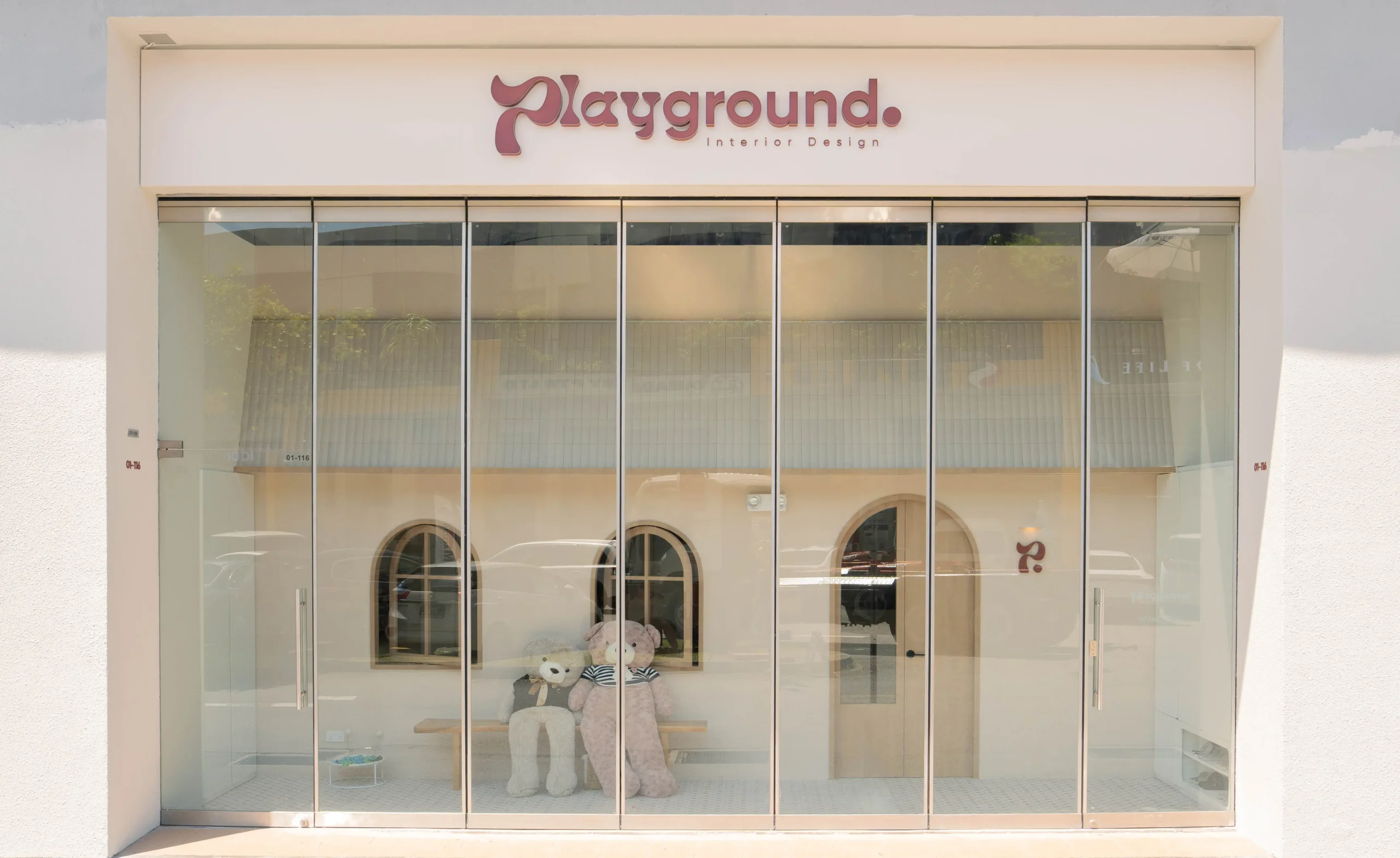Playground Interior studio facade with tall glass windows and signage.