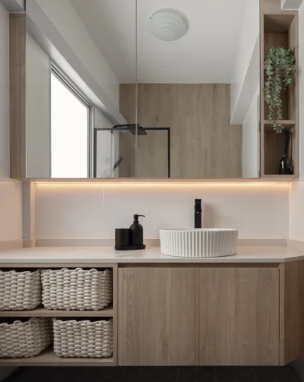 Bathroom vanity with vessel sink, black faucet, basket storage, and a window.
