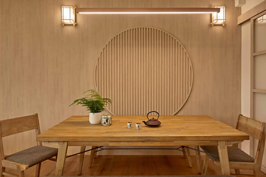 Dining area with a round slatted wood wall feature and warm sconces.